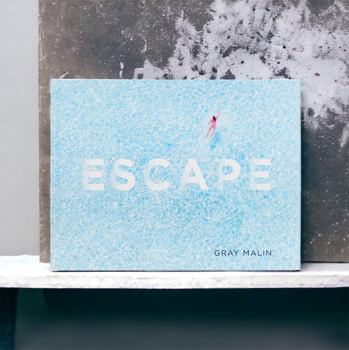 Escape by Gray Malin book with a pale blue ocean cover on a shelf