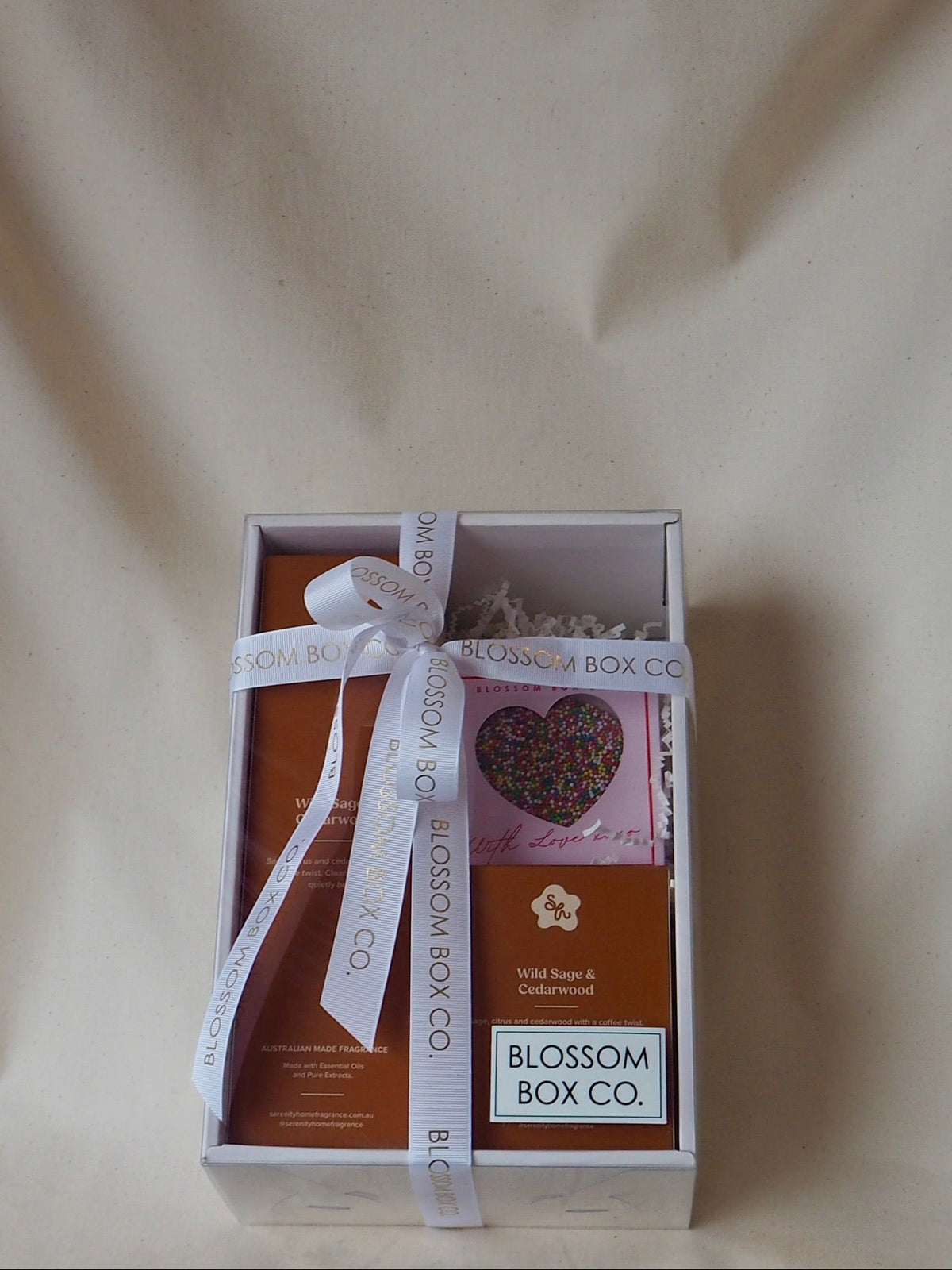Serenity Home Hamper with a diffuser, chocolate and gifts in a clear box tied with Blossom Box Co ribbon, photo 1 of 2
