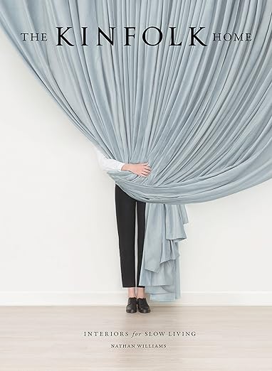 The Kinfolk Home book with a cover of a figure behind a pale blue curtain
