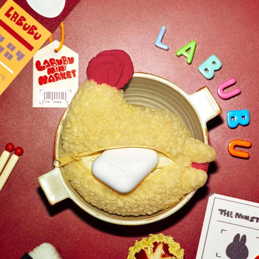 Fluffy yellow THE MONSTERS Wacky Mart Earphone Case holding earphones on a red table, photo 2 of 4