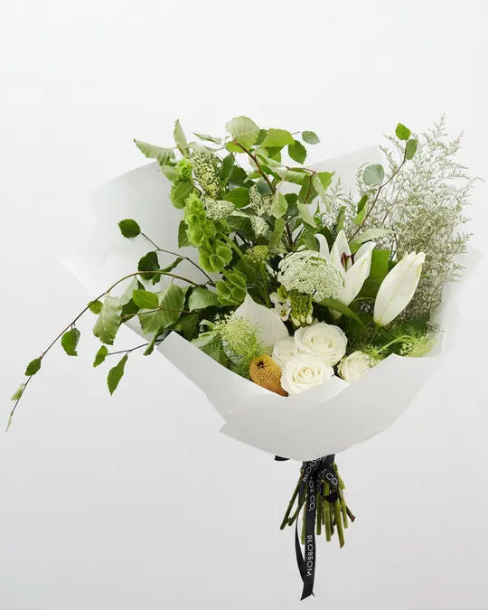 White lilies and soft greenery wrapped in white paper